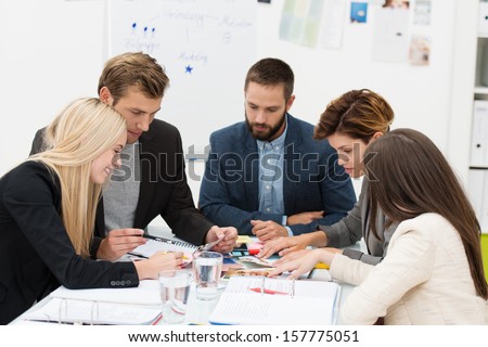 Diverse business team of dedicated young people sitting around a table in a meeting