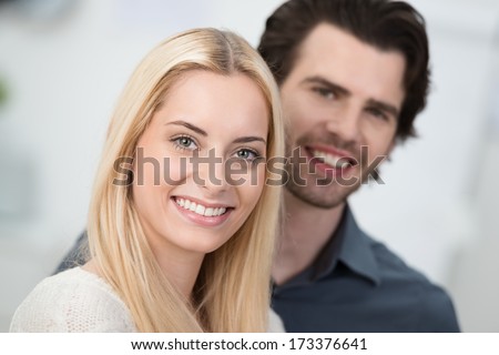 Beautiful smiling blond woman with a lovely wide friendly smile posing with a handsome young man with focus to her face