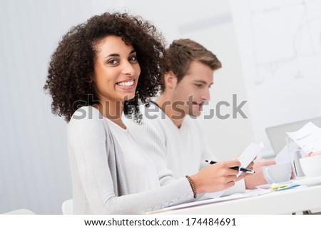 Beautiful African American Businesswoman Sitting In A Meeting Alongside A Handsome Male Colleague