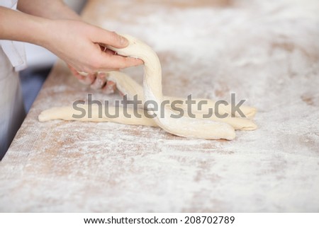 Closeup of female chef\'s hands preparing dough at kitchen counter in bakery