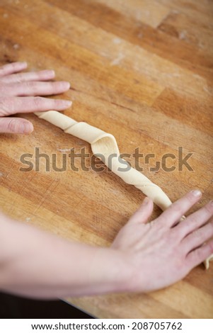 chef's hands on kitchen counter rolling dough
