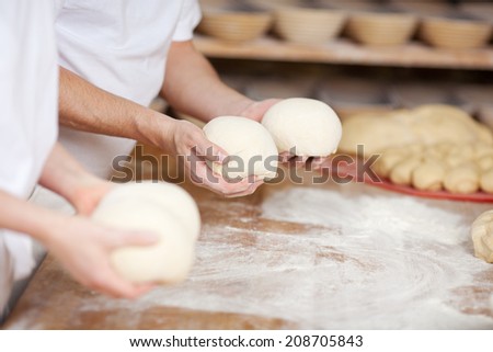 two chefs forming dough in order to prepare bread