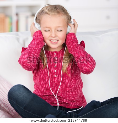 portrait of a female kid enjoying music with closed eyes