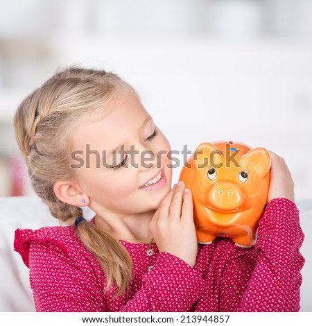 smiling girl holding piggy bank on her shoulder