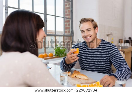 Happy Young Couple Having Snacks on White Table at the House Dining Area.