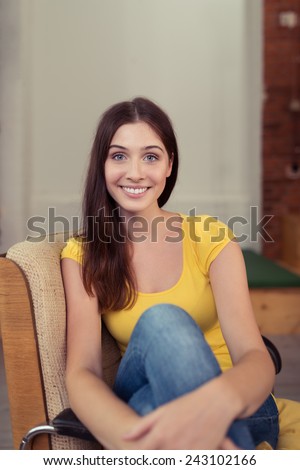 Close up Pretty Smiling Woman in Casual Clothing Sitting on Single Chair, with Crossed Legs, Looking at the Camera