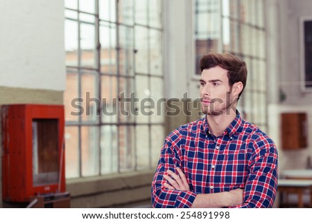 Thoughtful Handsome Man in Checkered Long Sleeve Shirt Looking Afar with Arms Crossing In Front his Body