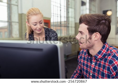 Close up Young Man Talking to Blond Woman at his Worktable Inside the Office.