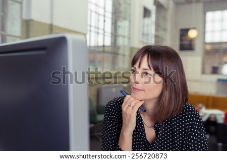 Close up Serious Office Woman Looking at Computer Screen with Hand on the Chin.