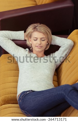 Close up Pretty Blond Young Woman in Casual Clothing Taking a Nap on the Sofa with Two Hands Behind her Head.