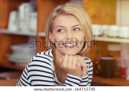 Close up Happy Young Blond Woman in Stripe Shirt Leaning on her Hands While Looking at the Left of the Frame.