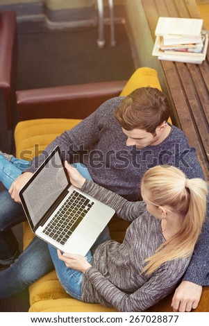 Aerial View of a Young Romantic Couple Sitting on the Couch at the Living Area While Looking at the Laptop Screen Together.