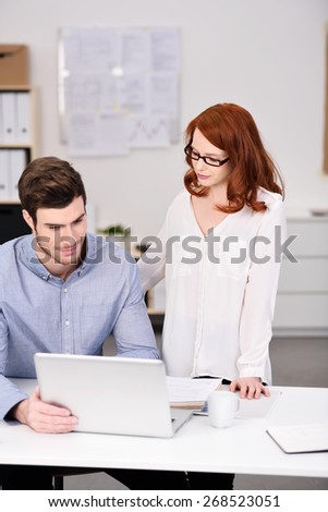 Young Professional Couple at the Worktable with Laptop Computer While Discussing Business Plans