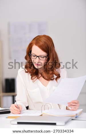Close up Busy Young Office Woman Sitting at her Worktable, Writing Document Seriously While Holding Other Papers.
