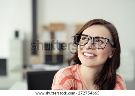 Smiling Young Woman Wearing Eyeglasses with Black Frames and Looking Up as if Daydreaming or Thinking of Something Pleasant