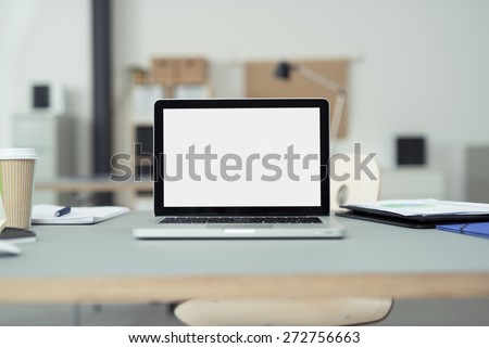Close up Laptop Computer on Top of Office Table of a Businessman with Empty White Screen, Emphasizing Copy Space.
