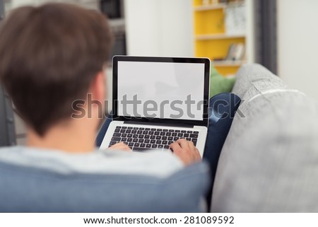 Man Relaxing on Sofa with Laptop Computer, Perspective View of Over Shoulder Looking from Behind at Blank Screen