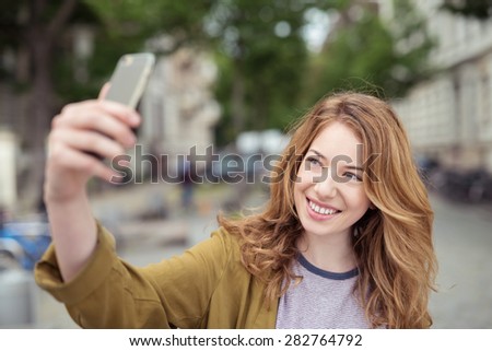 Close up Happy Blond Girl Taking Selfie Photo Using her Mobile Phone at the Street.