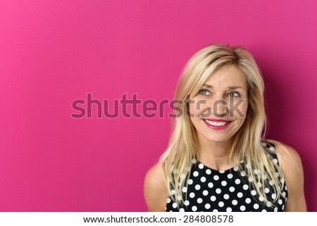 Close up Thoughtful Blond Adult Woman Looking up with a Smiling Facial Expression Against Pink Background with Copy Space
