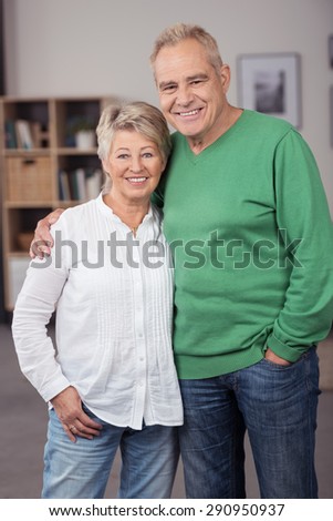 Portrait of a Sweet and Happy Middle Aged Couple in Casual Clothing Posing Inside their Home and Smiling at the Camera