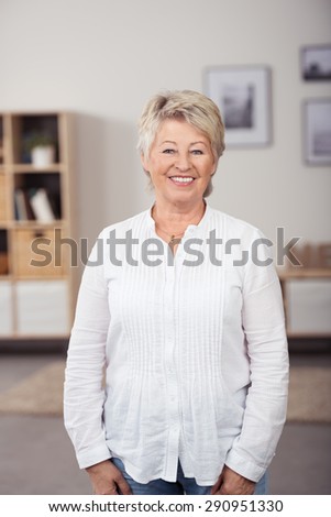 Portrait of a Pretty Matured Woman in Casual White Long Shirt, Posing at the Living Room and Looking at the Camera with a Toothy Smile.
