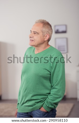 Portrait of a Thoughtful a Middle Aged Man in Casual Clothing, Standing Inside the House While Looking Into Distance with Hand on his Pocket