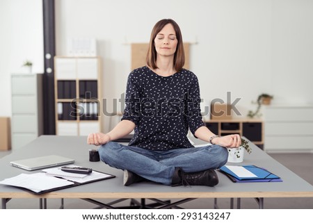Healthy Office Woman Sitting on the Table at the Boardroom While Doing Yoga Exercise In Front of the Camera.