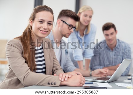 Pretty Young Office Worker in a Meeting at the Boardroom, Looking at the Camera with a Smiling Face.