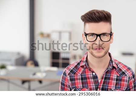 Close up Handsome Young Man with Eyeglasses Smiling at Camera Inside the Office.