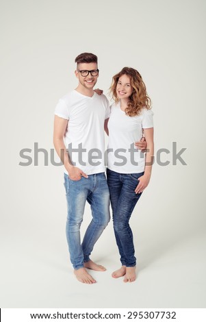 Full Length Shot of Sweet Young Couple in Casual White Shirt with Copy Space and Blue Jeans Smiling at the Camera, Isolated on White Background.