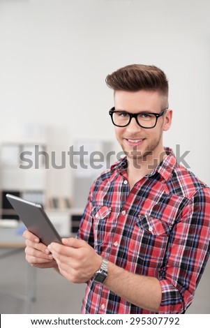 Portrait of a Smiling Young Office Guy in Casual Outfit, Holding a Tablet Computer and Looking at the Camera.