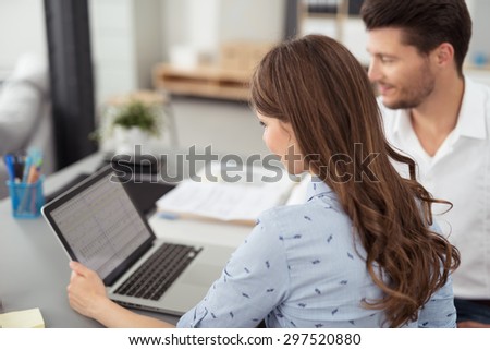 Young Professional Business Couple Watching Something on Laptop Computer at the Table Inside the Office.