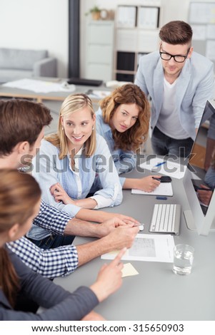 Five Young Office Workers Brainstorming for New Ideas at the Table with Computer Inside the Office.