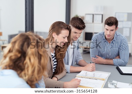 Young Office Workers in a Meeting Inside the Office, Reviewing the Compiled Documents on Top the Table