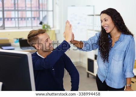 colleagues giving high five as they are celebrating a good result