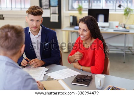 businesspeople sitting at desk at a modern office discussing project