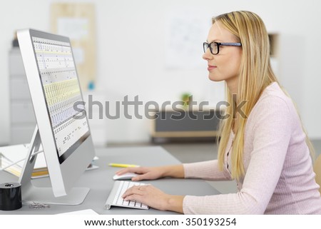 young blond businesswoman working on computer inside the workplace