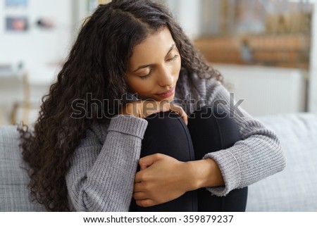 tired woman relaxing at home with her head on her knees and closed eyes