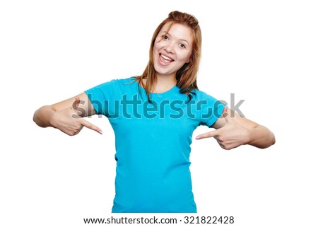 t-shirt design concept. Excited happy young woman pointing to empty space on her blue t-shirt with both hands, isolated on white
