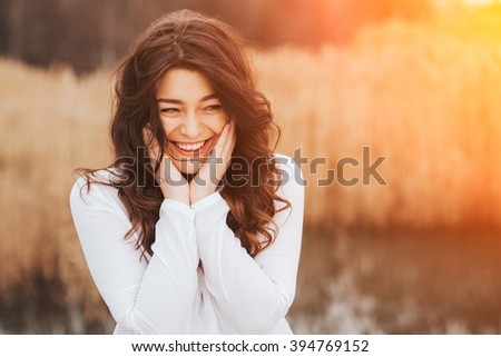 beautiful sunny portrait of a girl wearing white clothes. Face laughing woman outdoors with copy space