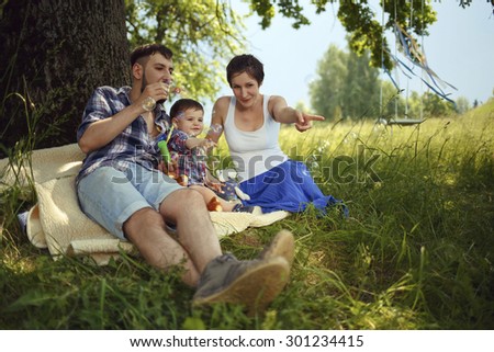 Happy family. Mother, father and son blowing bubbles in the park