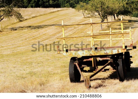 old farm trailer in harvested field