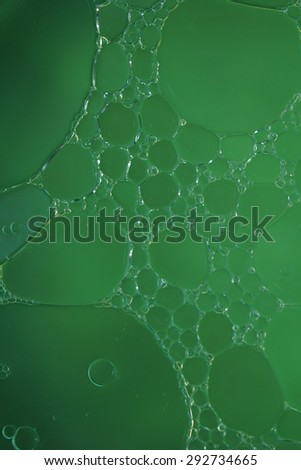 Bubble of oil and water in green background, shot with macro lens.There are many macro bubble inside the big one.