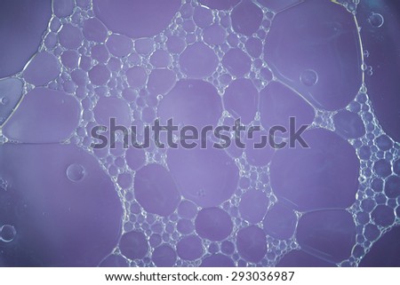 Bubble of oil and water in purple background, shot with macro lens.There are many macro bubble inside the big one.