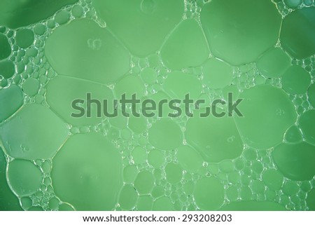 Bubble of oil and water in green background, shot with macro lens.There are many macro bubble inside the big one.