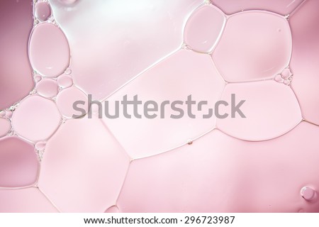 Bubble of oil and water in pink background, shot with macro lens. There are many tiny bubbles inside.