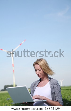 Engineer with Laptop stand at Windturbine and testing Telemetry
