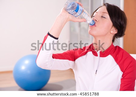 young woman with stability ball sport coach drinking