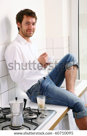 young man sitting in kitchen and have breakfast