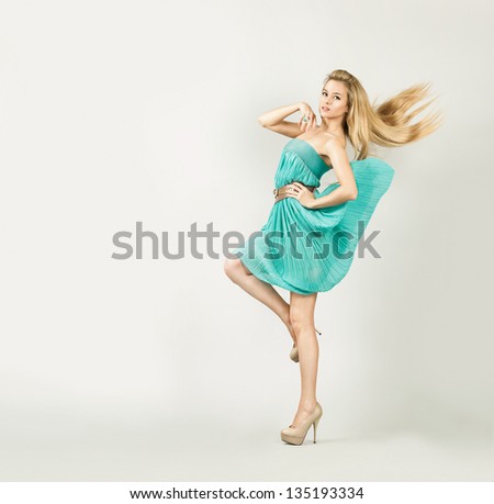 Woman In Turquoise Dress On Gray Backgound